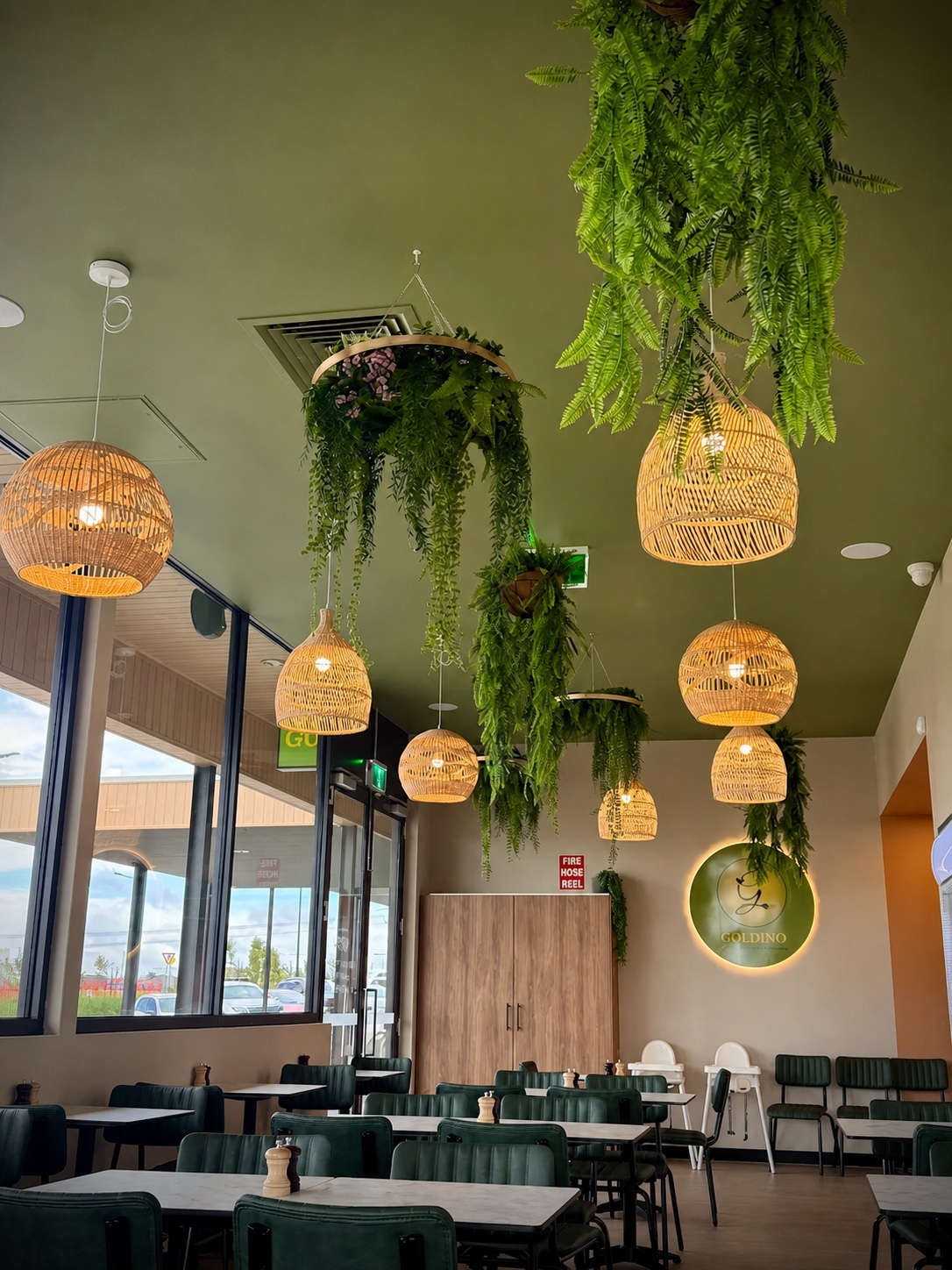 Goldino cafe interior with hanging plants and warm woven lights